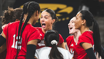 Nebraska volleyball players celebrate a point at Iowa.