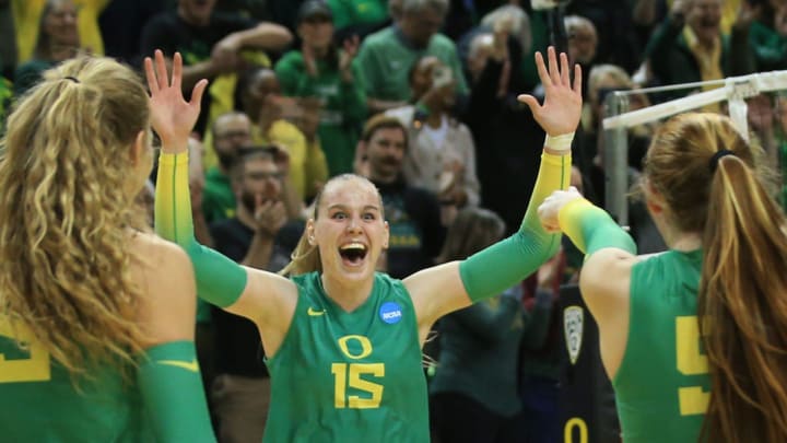 Oregon's Mimi Colyer, center, celebrates the winning shot against Arkansas during the final set in their NCAA Round 2 match in Eugene Dec. 3, 2022.