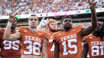 Texas defensive back Graham Gillespie (38) and linebacker S'Maje Burrell (15) put their \"Horns Up\"