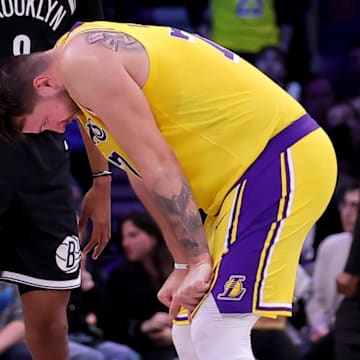 Mar 10, 2025; Brooklyn, New York, USA; Los Angeles Lakers guard Luka Doncic (77) reacts in front of Brooklyn Nets forward Ziaire Williams (8) during the fourth quarter at Barclays Center. Mandatory Credit: Brad Penner-Imagn Images