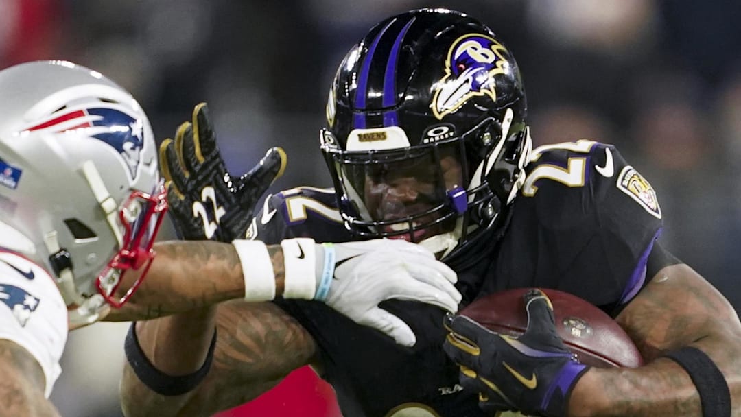 Baltimore Ravens running back Derrick Henry (22) runs the ball against New England Patriots cornerback Christian Gonzalez.