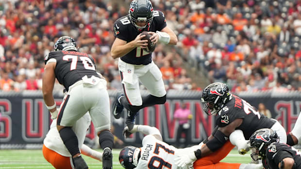Houston Texans quarterback Davis Mills (10) jumps over Denver Broncos defensive tackle Malcolm Roach (97).
