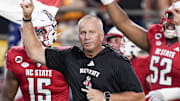 Sep 7, 2024; Charlotte, North Carolina, USA; North Carolina State Wolfpack head coach Dave Doeren leads his team onto the field against the Tennessee Volunteers during the first quarter at the Dukes Mayo Classic at Bank of America Stadium. Mandatory Credit: Jim Dedmon-Imagn Images
