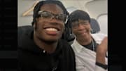 Travis Hunter sits next to Sandy Combs on an airplane.
