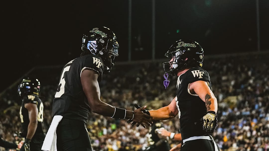 Nov 15, 2025; Winston-Salem, North Carolina, USA; Wake Forest Demon Deacons quarterback Deshawn Purdie (5) and wide receiver Carlos Hernandez (8) celebrate after a play against the North Carolina Tar Heels at Allegacy Federal Credit Union Stadium. Mandatory Credit: Wake Forest Athletics via Imagn Images