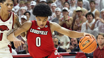 Dec 3, 2025; Fayetteville, Arkansas, USA; Louisville Cardinals guard Mikel Brown Jr (0) dribbles around Arkansas Razorbacks guard Meleek Thomas (1) during the second half at Bud Walton Arena. Arkansas won 89-80. Mandatory Credit: Nelson Chenault-Imagn Images