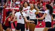 The Huskers celebrate a double block from Skyler Pierce (21) and Manaia Ogbechie (14). 