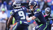 Nov 9, 2025; Seattle, Washington, USA; Seattle Seahawks quarterback Sam Darnold (14) hands the ball off to Seattle Seahawks running back Kenneth Walker III (9) during the first quarter at Lumen Field. 