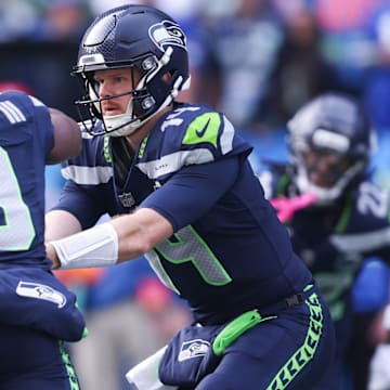 Nov 9, 2025; Seattle, Washington, USA; Seattle Seahawks quarterback Sam Darnold (14) hands the ball off to Seattle Seahawks running back Kenneth Walker III (9) during the first quarter at Lumen Field. 