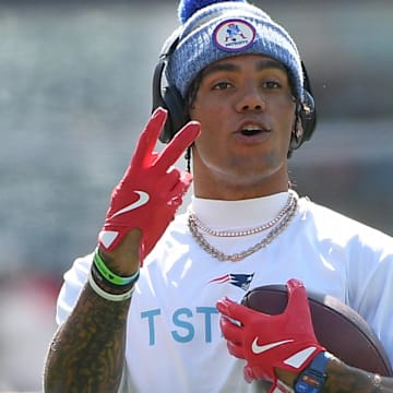 Sep 28, 2025; Foxborough, Massachusetts, USA;  New England Patriots cornerback Christian Gonzalez (0) signals to a teammate during warmups prior to a game against the Carolina Panthers at Gillette Stadium. Mandatory Credit: Bob DeChiara-Imagn Images