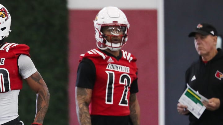 The Louisville football coaching staff gave instruction to DB Tamarion McDonald (12) during spring practice at the Trager practice facility