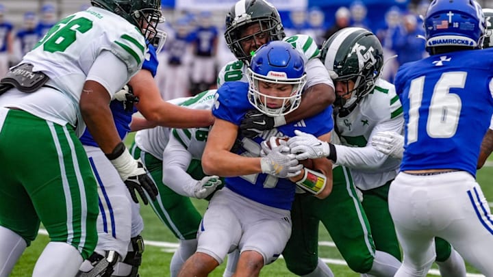 Novi Detroit Catholic Central's Jaden Pydyn - an Army incoming 2025 freshman - is wrapped by Cass Tech defense during the first half of the MHSAA semifinals at Troy Athens high school on Saturday, Nov. 23, 2024.