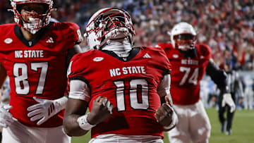 Nov 29, 2025; Raleigh, North Carolina, USA;  NC State Wolfpack quarterback Will Wilson (10) makes a touchdown and celebrates during the first half of the game against North Carolina Tar Heels at Carter-Finley Stadium.  Mandatory Credit: Jaylynn Nash-Imagn Images