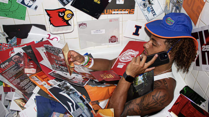 Justin Hill poses in a bathtub with his recruiting mail