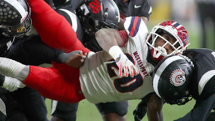 McKeesport's Kemon Spell (20) gets taken to the ground by multiple Aliquippa defenders during the second half of the WPIAL 4A Championship game Friday evening at Acrisure Stadium in Pittsburgh, PA.