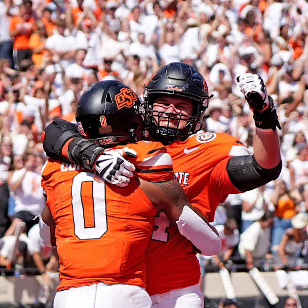 Oklahoma State's Ollie Gordon II (0) celebrates a touchdown with Preston Wilson (74) in double over time.