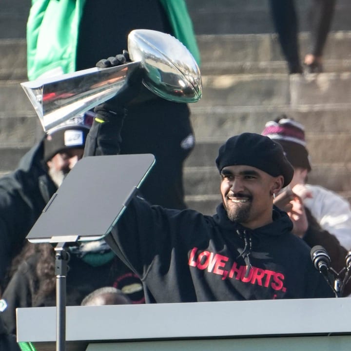 Jalen Hurts takes the Vince Lombardi trophy to the podium as he speaks during the Philadelphia Eagles Super Bowl celebration.