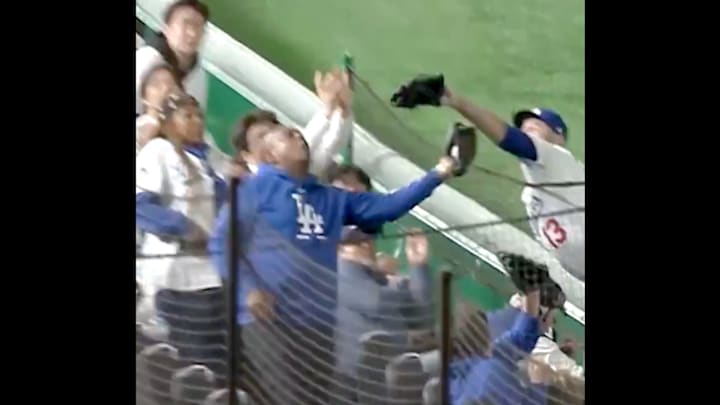 Former USC and NFL quarterback Rodney Peete catches a ball in front of Dodgers infielder Max Muncy.