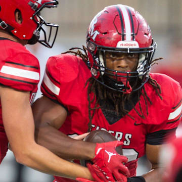 T.R. Miller's Nathan Commander (5) hands the ball off to Myles Johnson (32) during the AHSAA Kickoff game at Cramton Bowl in Montgomery, Ala., on Thursday, Aug. 22, 2024. T.R. Miller and Reeltown are tied 7-7 at halftime.