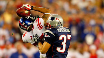 Giants receiver David Tyree catches a pass while in the clutches of Patriots safety Rodney Harrison en route to New York's 17-14 victory over New England in Super Bowl XLII.