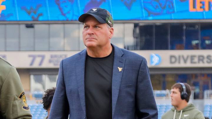 Nov 8, 2025; Morgantown, West Virginia, USA; West Virginia Mountaineers head coach Rich Rodriguez walks with his team as they arrive before their game against the Colorado Buffaloes at Milan Puskar Stadium. Mandatory Credit: Ben Queen-Imagn Images
