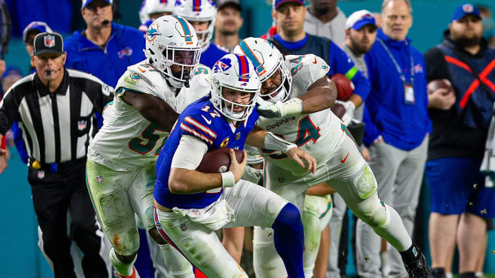 Buffalo Bills quarterback Josh Allen (17), runs by several Dolphins defenders on his way to a first down, during second half action of their NFL football game Jan 07, 2024, in Miami Gardens.