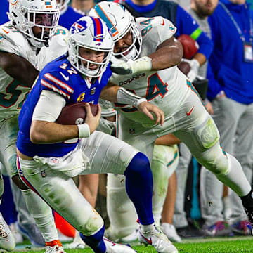 Buffalo Bills quarterback Josh Allen (17), runs by several Dolphins defenders on his way to a first down, during second half action of their NFL football game Jan 07, 2024, in Miami Gardens.