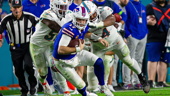 Buffalo Bills quarterback Josh Allen (17), runs by several Dolphins defenders on his way to a first down, during second half action of their NFL football game Jan 07, 2024, in Miami Gardens.