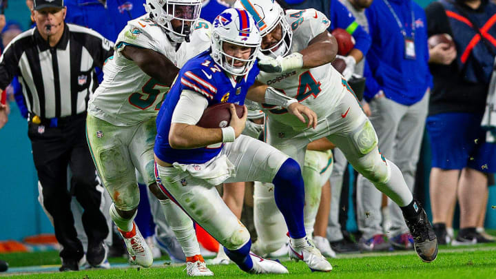 Buffalo Bills quarterback Josh Allen (17), runs by several Dolphins defenders on his way to a first down, during second half action of their NFL football game Jan 07, 2024, in Miami Gardens.