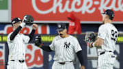 Oct 2, 2025; Bronx, New York, USA; New York Yankee outfielders Cody Bellinger (35), Trent Grisham (12) and Aaron Judge (99) react  following game three of the Wildcard round for the 2025 MLB playoffs against the Boston Red Sox at Yankee Stadium. Mandatory Credit: Vincent Carchietta-Imagn Images