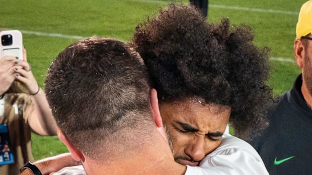 Oregon head coach Dan Lanning, left, embraces Oregon quarterback Dante Moore