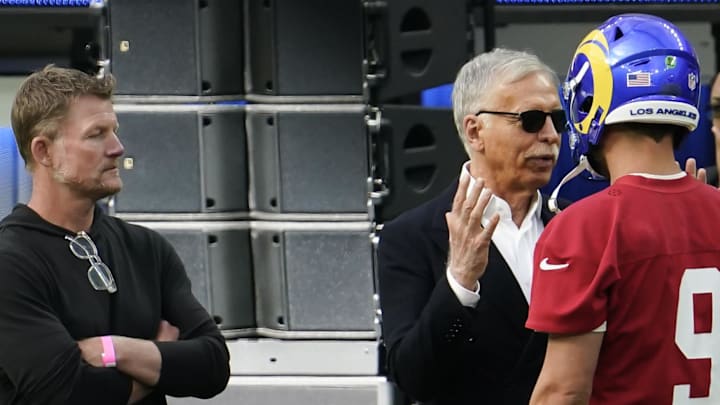 Los Angeles Rams owner Stan Kroenke (center) talks to quarterback Matthew Stafford (9) with general manager Les Snead. Mandatory Credit: Robert Hanashiro-Imagn Images