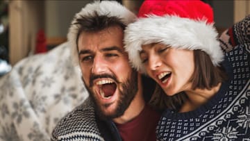Two people singing in Santa hats