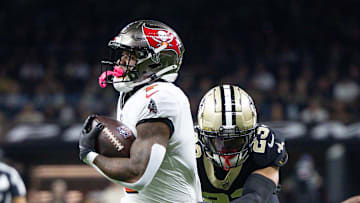Oct 13, 2024; New Orleans, Louisiana, USA;  Tampa Bay Buccaneers running back Bucky Irving (7) runs against New Orleans Saints cornerback Marshon Lattimore (23) during he first half at Caesars Superdome. Mandatory Credit: Stephen Lew-Imagn Images