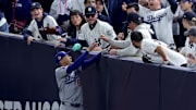Oct 29, 2024; New York, New York, USA; Los Angeles Dodgers shortstop Mookie Betts (50) makes a catch in foul territory as a New York Yankees fan interferes during the first inning in game four of the 2024 MLB World Series at Yankee Stadium. 