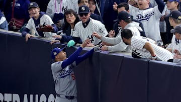 Oct 29, 2024; New York, New York, USA; Los Angeles Dodgers shortstop Mookie Betts (50) makes a catch in foul territory as a New York Yankees fan interferes during the first inning in game four of the 2024 MLB World Series at Yankee Stadium. 