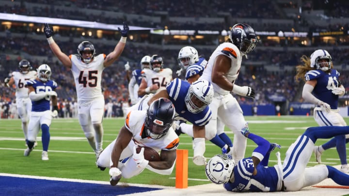 Denver Broncos running back Tyler Badie (36) scores a touchdown with offensive tackle Demontrey Jacobs (71) leading the way vs. the Indianapolis Colts. 