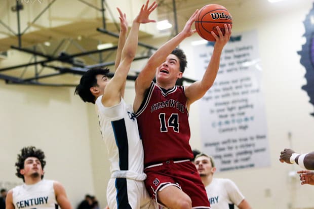 Sherwood senior Brady Hix tries to power his way to the basket in the Bowmen’s 62-48 Pacific Conference win at Century.