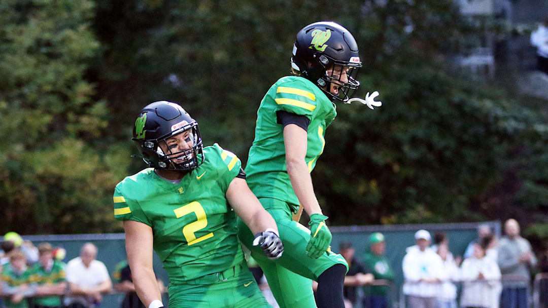 Will Ingle (left) and Wyatt Smiley celebrate after a West Linn touchdown Friday. The Lions beat Sherwood, 35-0.