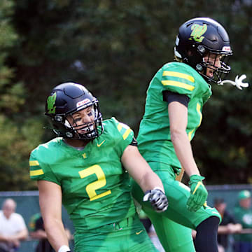 Will Ingle (left) and Wyatt Smiley celebrate after a West Linn touchdown Friday. The Lions beat Sherwood, 35-0.