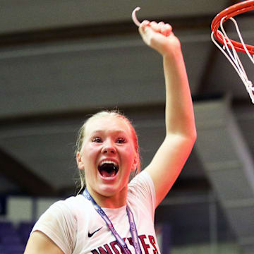 Tualatin junior Ries Miadich cuts part of the net after the Timberwolves’ 63-58 win over Clackamas in the Class 6A state championship game.