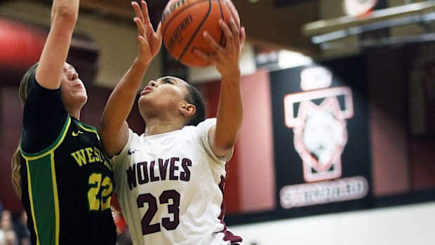 Tualatin freshman Kendall Dawkins powers her way to the basket against West Linn sophomore Kaylor Buse.