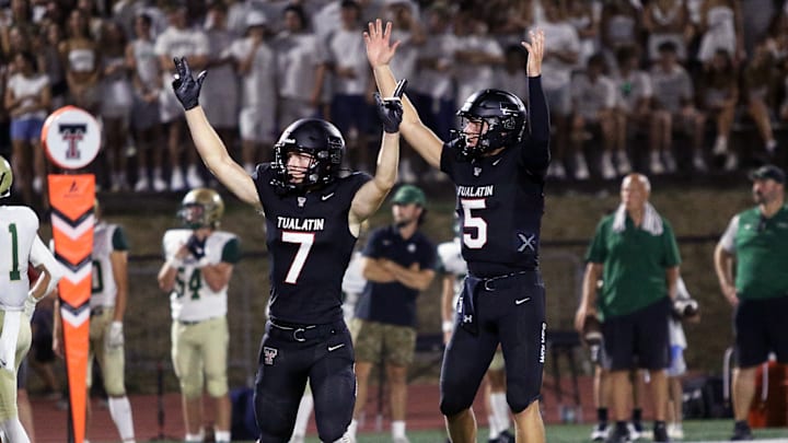 Tualatin seniors Calvin Evans (left) and Nolan Keeney celebrate after one of the Timberwolves' scores Friday night against Jesuit.