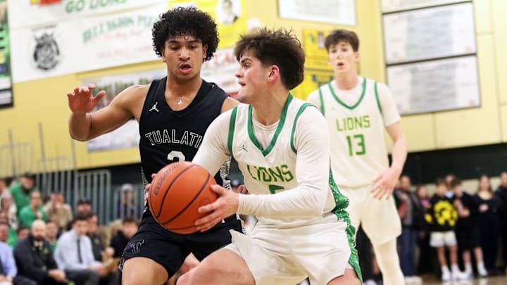 West Linn senior Jalen Snook looks to get past Tualatin’s Pat Vialva Jr. during the Lions’ come-from-behind win over the Timberwolves on Feb. 28 at West Linn High School.
