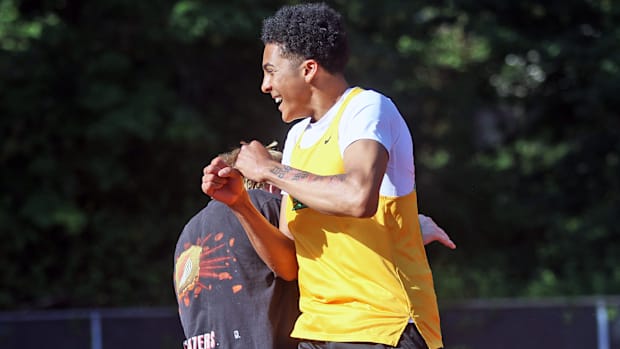 West Linn senior Warren Stanton smiles and celebrates after clearing 6-6 in the high jump.