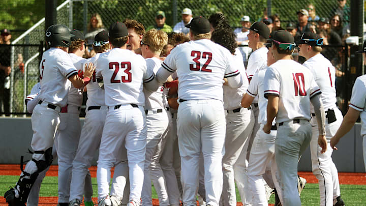 The Bowmen players mob senior Connor Parry after his walk-off home run in the team’s state playoff win over West Salem.