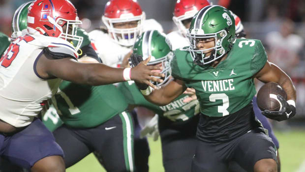 Venice running back Jamarice Wilder tries to avoid the grasp of Manatee defensive lineman Ean Johnson-Kelley during a game la