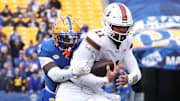 Nov 29, 2025; Pittsburgh, Pennsylvania, USA;  Miami Hurricanes quarterback Carson Beck (11) runs the ball as Pittsburgh Panthers linebacker Rasheem Biles (3) tackles during the first quarter at Acrisure Stadium. Mandatory Credit: Charles LeClaire-Imagn Images