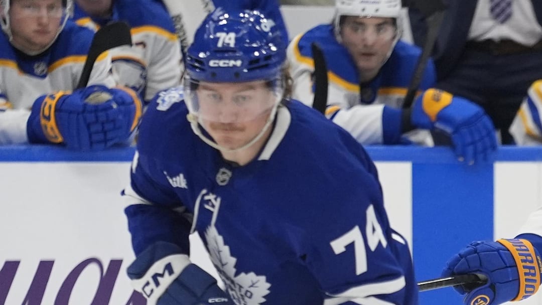 Jan 27, 2026; Toronto, Ontario, CAN; Buffalo Sabres defenseman Bowen Byram (4) tries to slow down Toronto Maple Leafs forward Bobby McMann (74) during the third period at Scotiabank Arena. Mandatory Credit: John E. Sokolowski-Imagn Images
