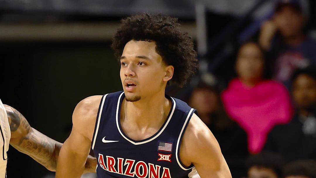 Jan 17, 2026; Orlando, Florida, USA;  Arizona Wildcats guard Brayden Burries (5) dribbles around Central Florida Knights forward Jordan Burks (99) in the first half at Addition Financial Arena. Mandatory Credit: Russell Lansford-Imagn Images